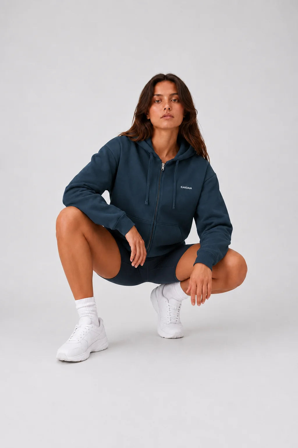 Sweat à capuche zippé femme bleu marine en coton bio porté accroupie