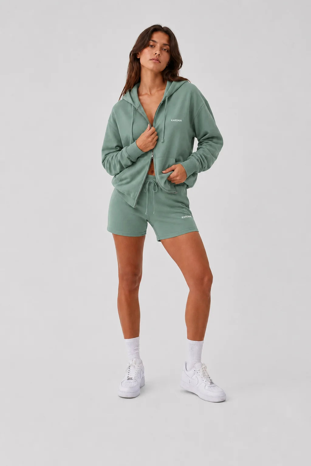 Sweat zippé femme vert argile en coton bio avec main sur la fermeture