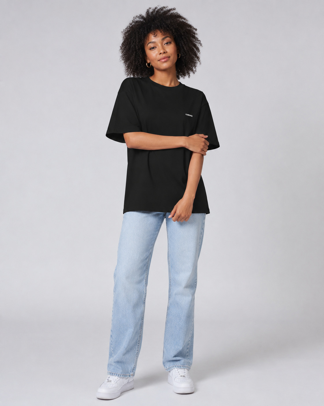 T-shirt noir oversize pour femme en coton biologique porté avec un jean clair