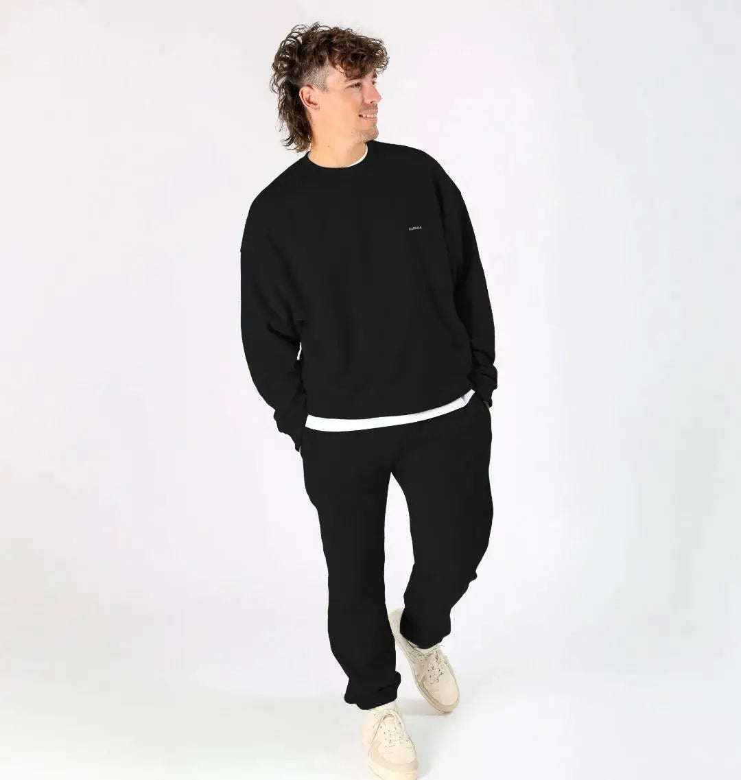 homme portant un pull noir oversize KARDAIA, style minimaliste en studio