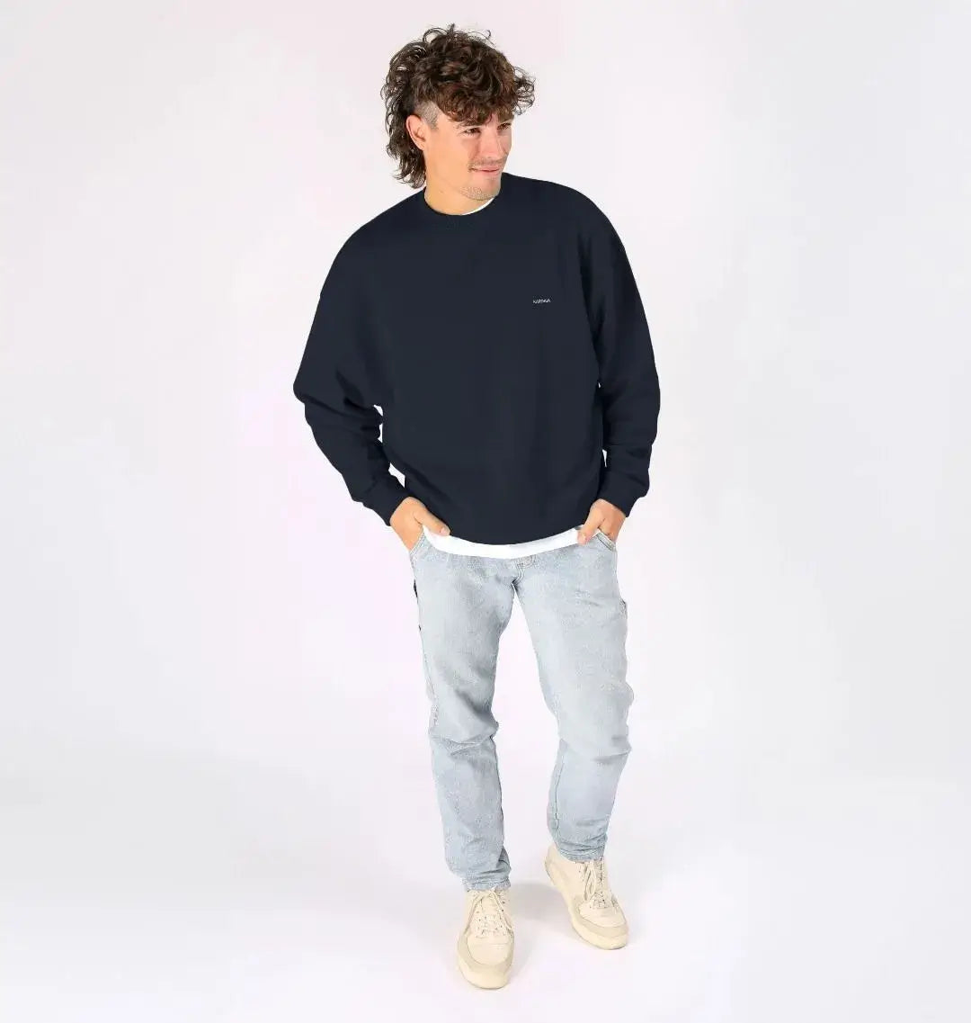 pull oversize bleu marine KARDAIA porté par un homme, ambiance studio moderne
