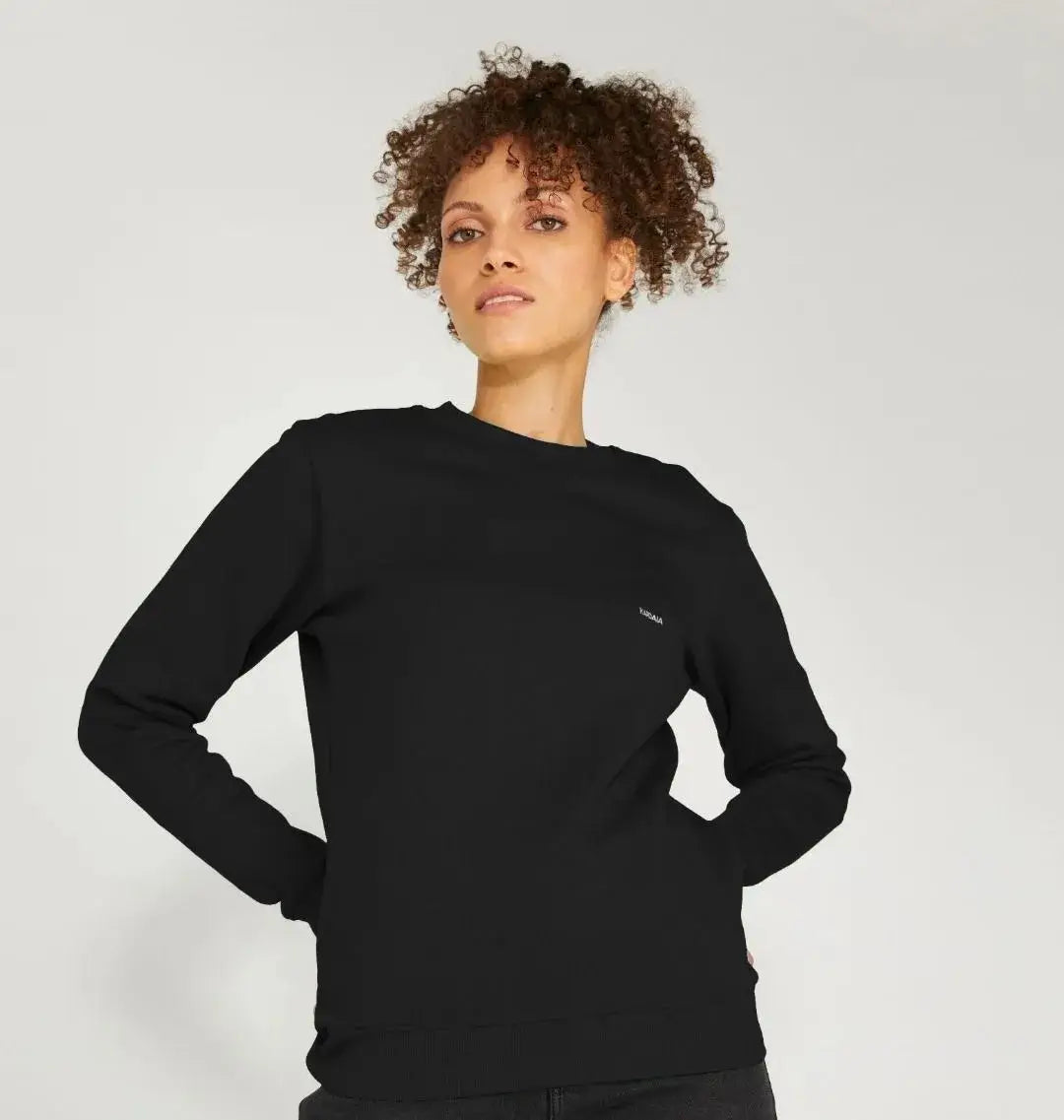 femme portant un pull ras cou noir minimaliste manches longues coupe droite