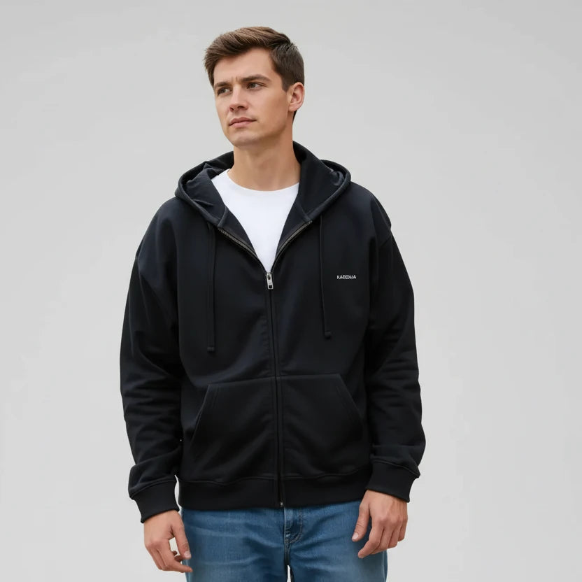 homme portant un sweat zippé noir KARDAIA sur la plage, style décontracté et naturel