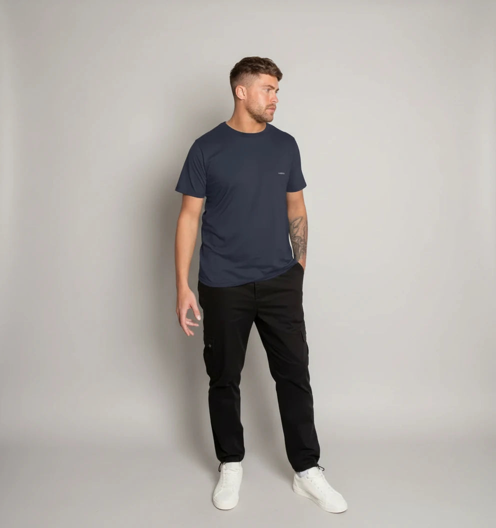 t-shirt basic bleu marine KARDAIA porté par un homme debout devant un mur