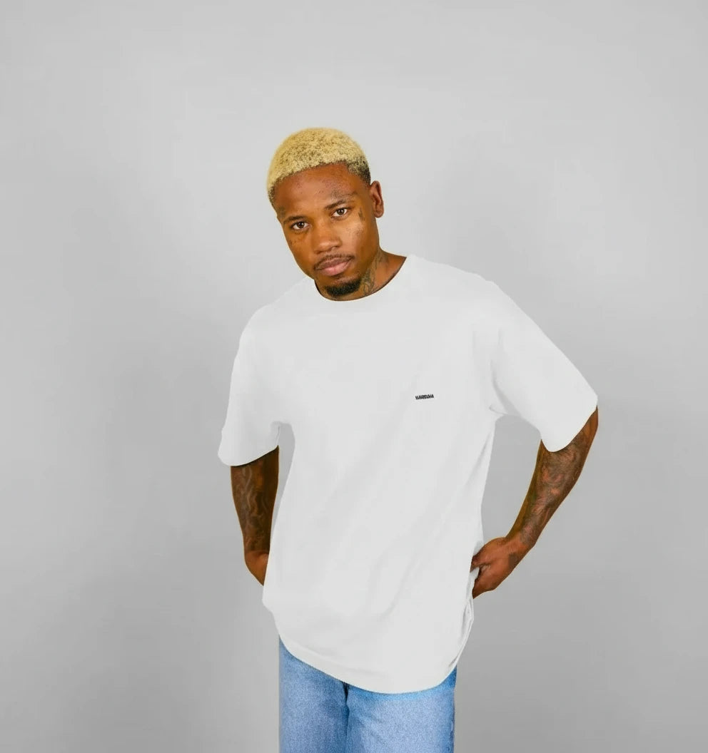 t-shirt oversize blanc KARDAIA porté par un homme devant fond sable
