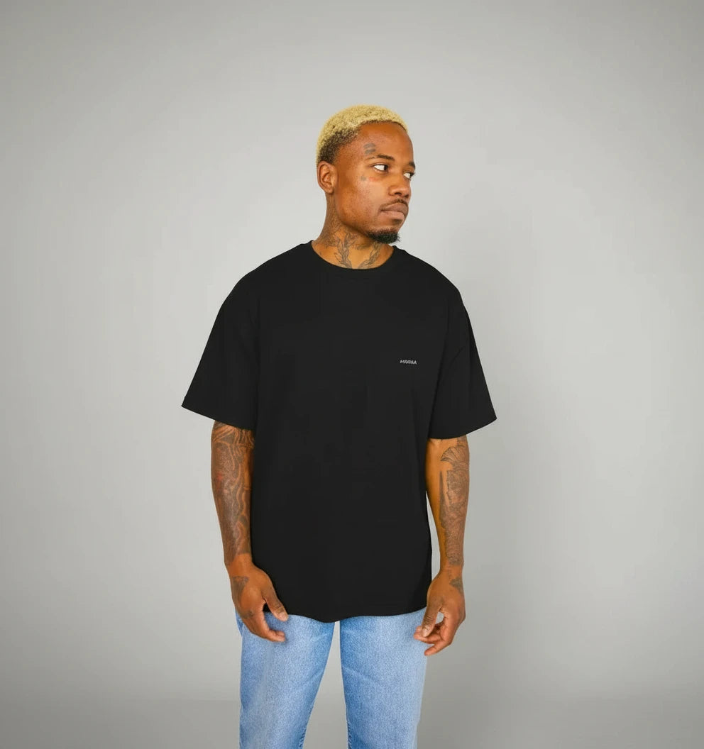 t-shirt oversize noir KARDAIA porté par un homme, vue de profil, fond studio clair