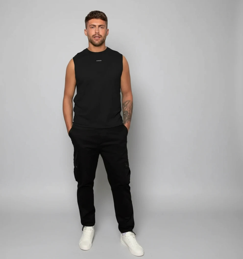 silhouette complète d’un homme en débardeur noir KARDAIA avec pantalon cargo noir et baskets blanches