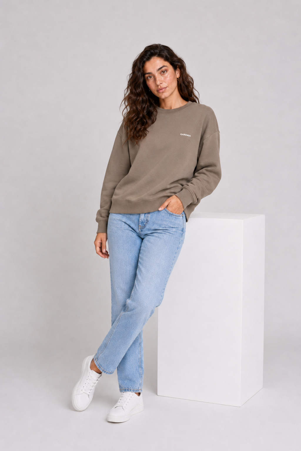 Pull oversize taupe pour femme en coton biologique porté avec un jean bleu clair