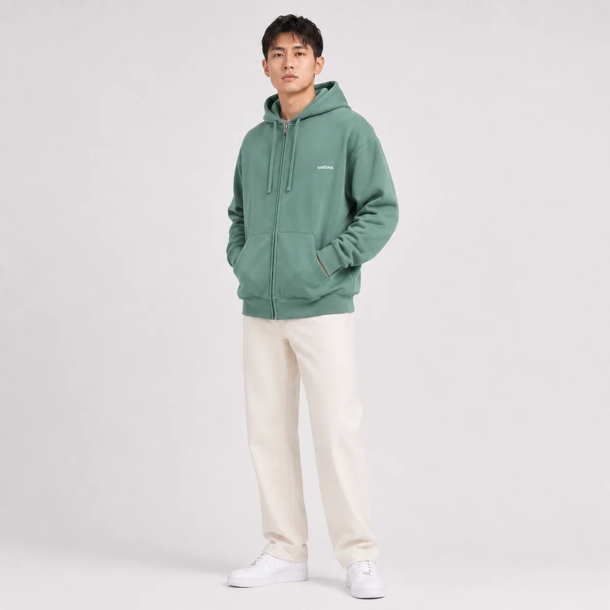 Photo studio d’un homme portant un sweat à capuche Kardaia vert sauge