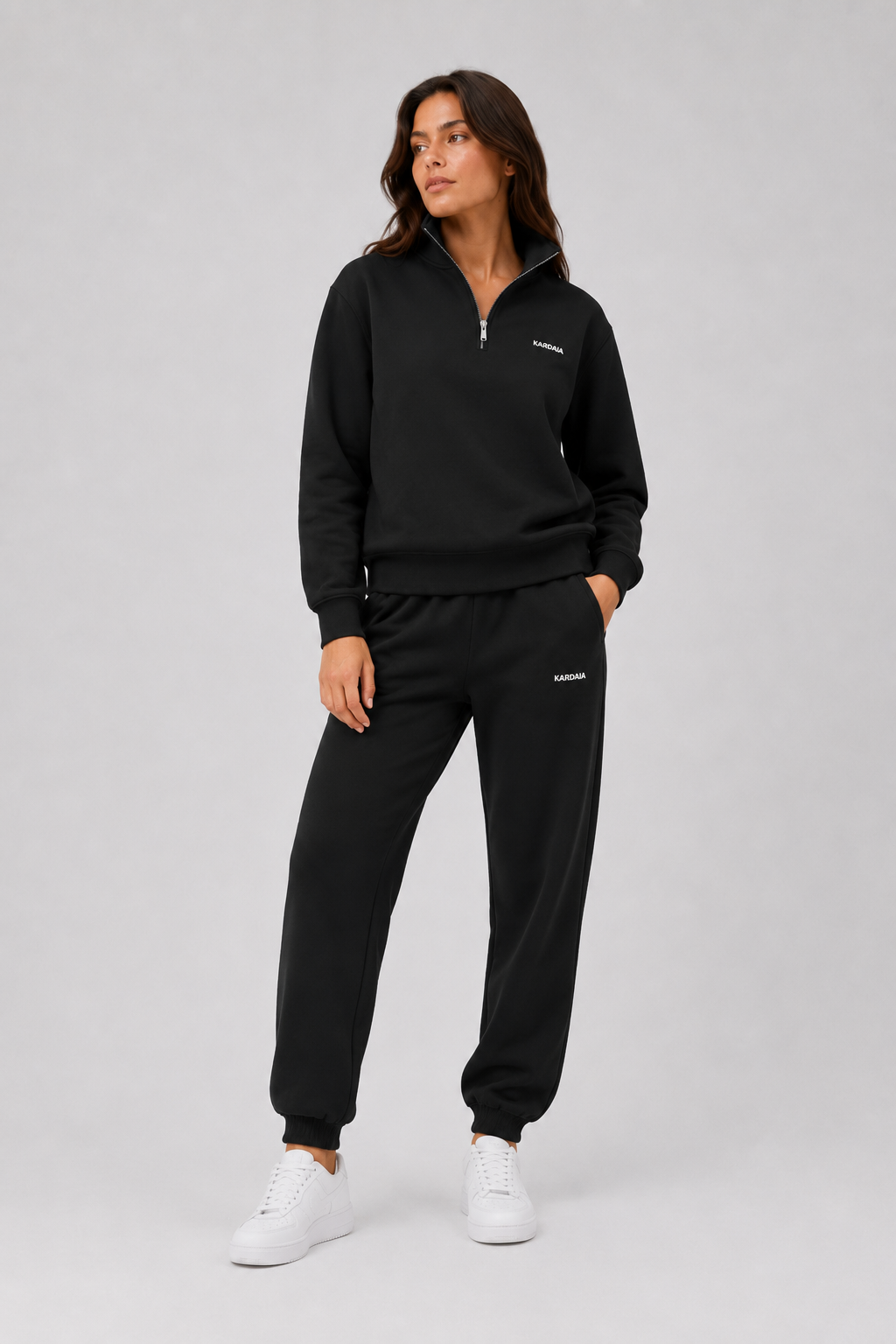 Femme portant un ensemble noir avec sweat quart de zip en coton biologique et jogging
