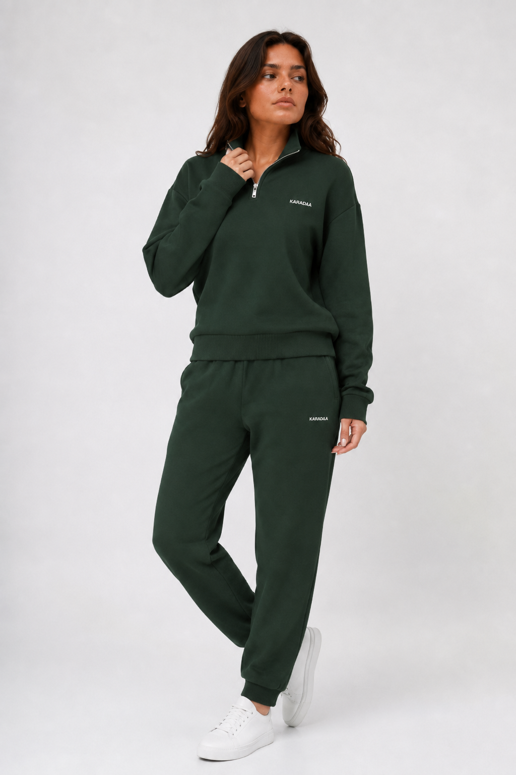 Femme portant un sweat quart de zip vert foncé en coton biologique avec jogging assorti