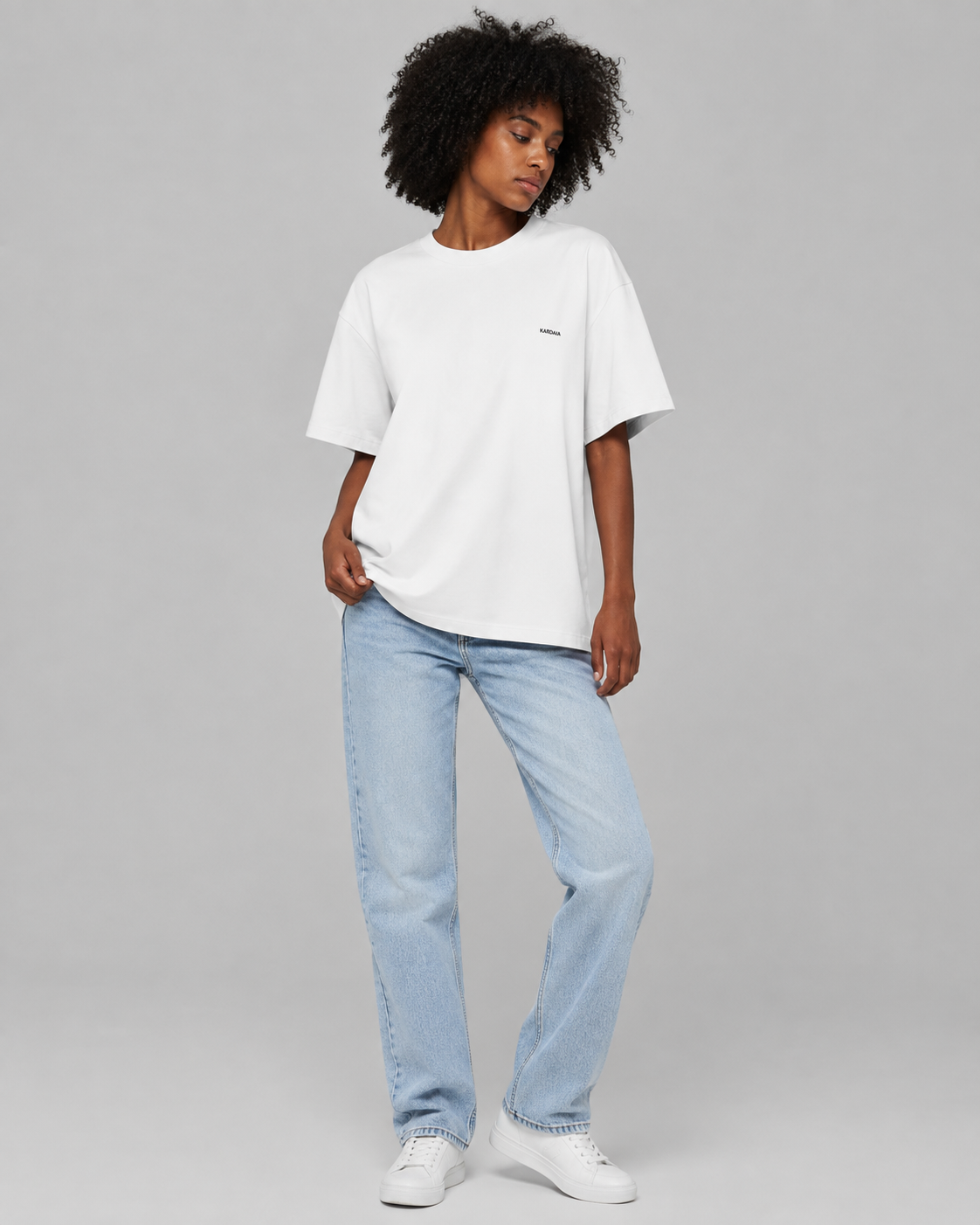 Femme portant un t-shirt oversize blanc en coton biologique avec un jean bleu clair