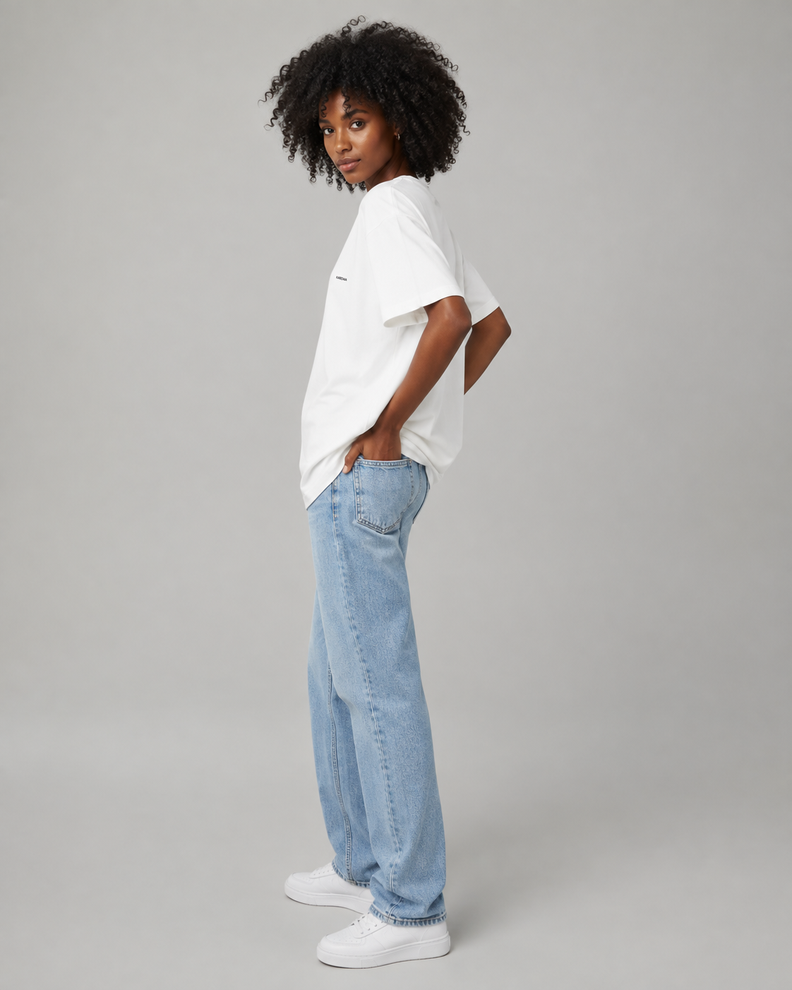 T-shirt blanc oversize pour femme en coton biologique présenté de profil avec un jean clair