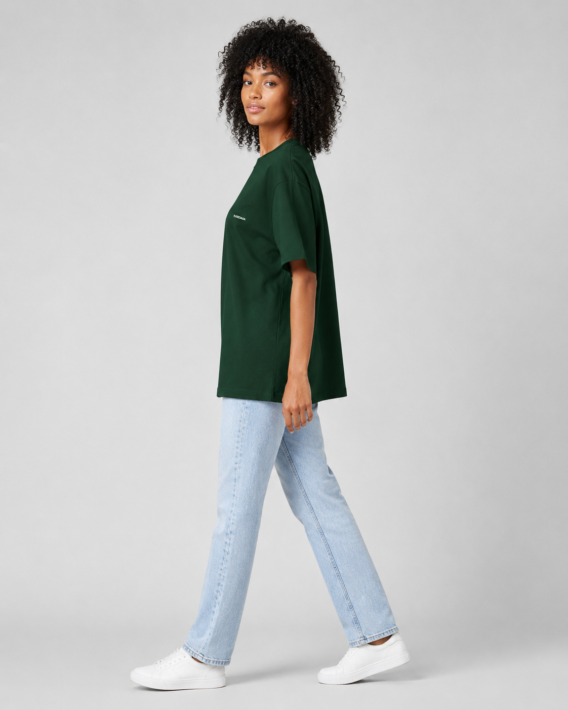 T-shirt oversize vert forêt pour femme en coton biologique vu de profil avec un jean clair