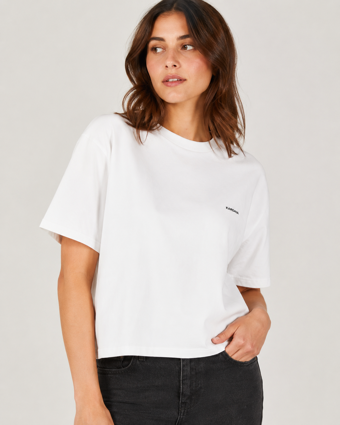 Gros plan sur un t-shirt boxy femme blanc en coton biologique porté avec un jean noir
