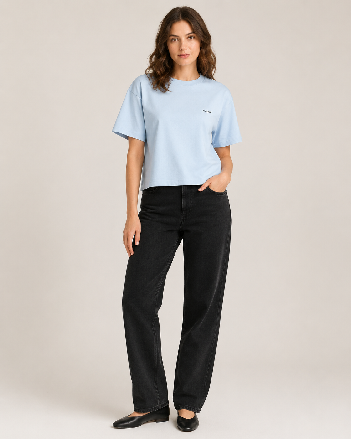 Femme portant un t-shirt boxy bleu clair en coton biologique avec un jean noir