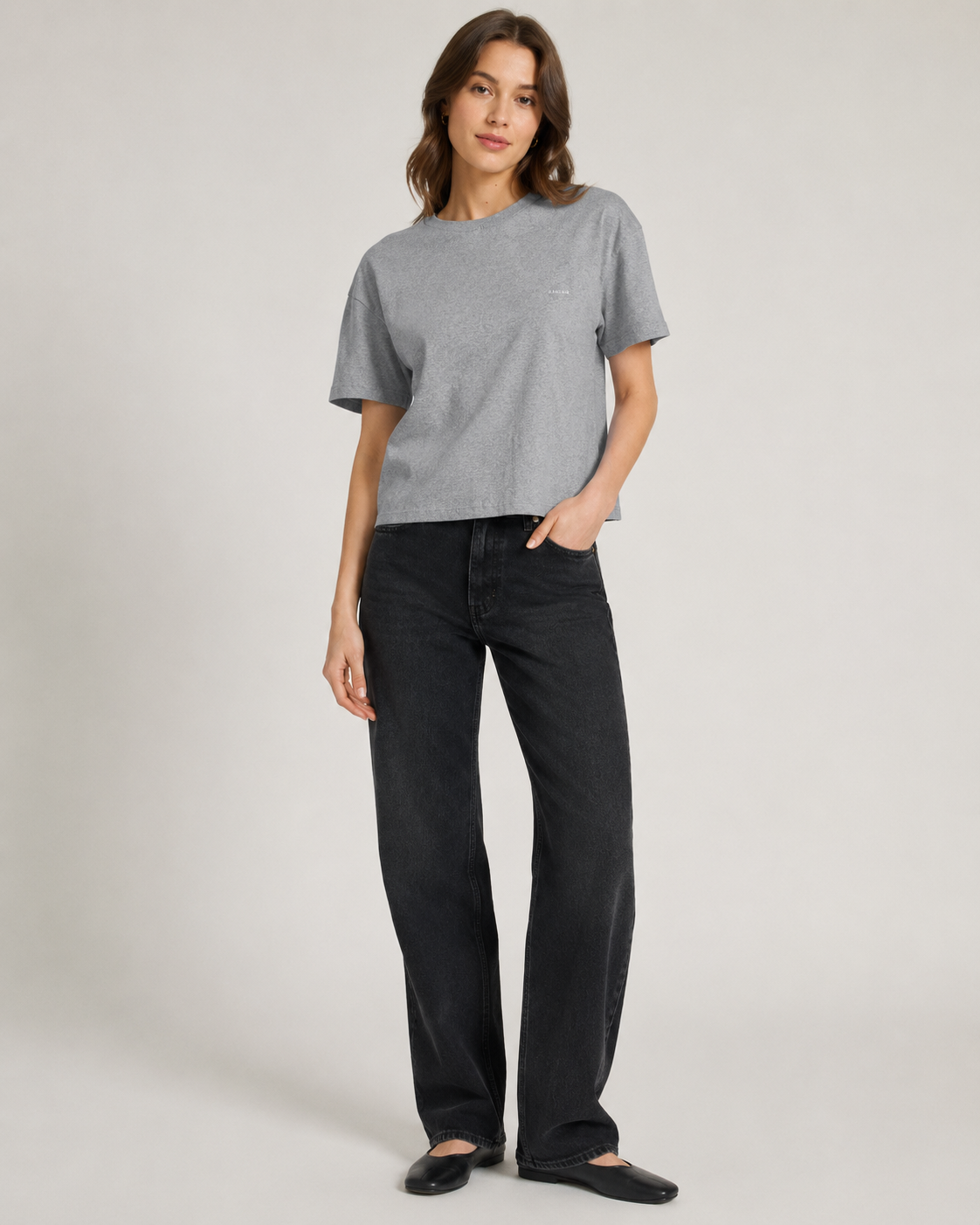 Femme portant un t-shirt boxy gris chiné en coton biologique avec un jean noir