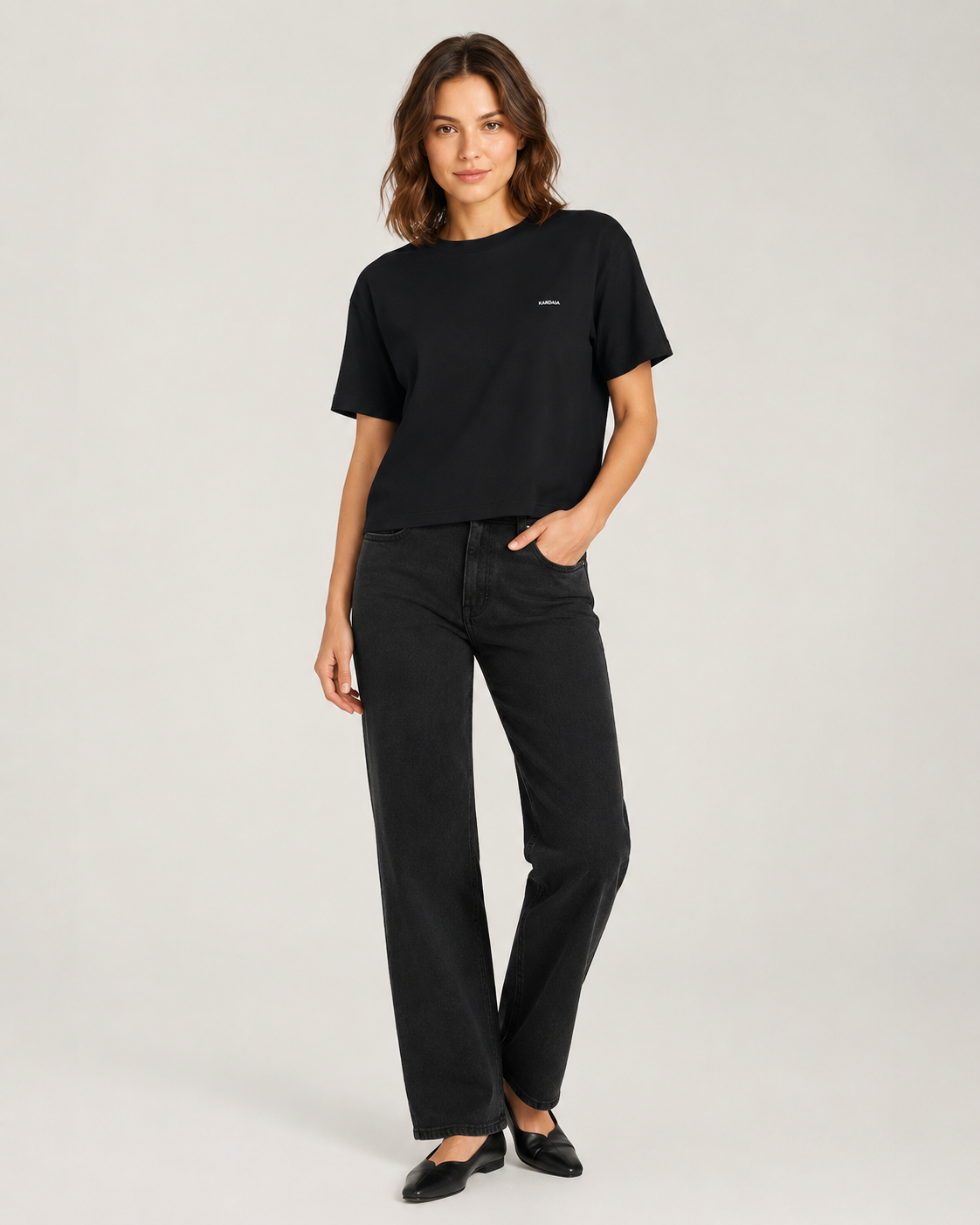 Femme portant un t-shirt boxy noir en coton biologique avec un jean noir