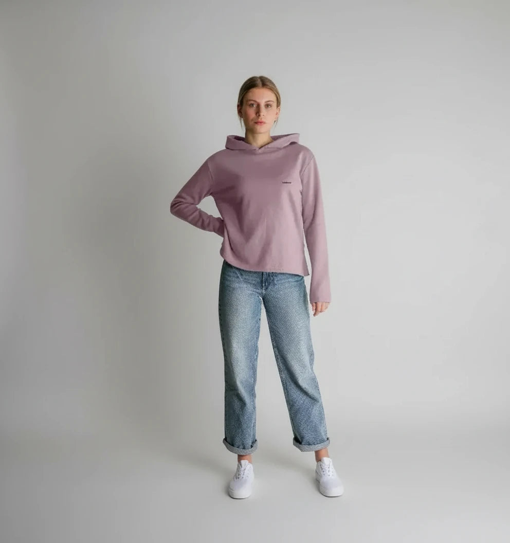 vue en pied d’une femme portant un sweat à capuche coton bio couleur mauve poudré coupe droite