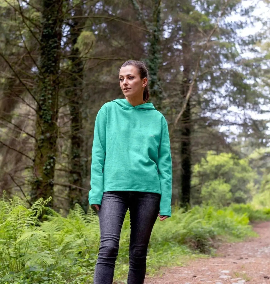femme portant un sweat à capuche émeraude KARDAIA en forêt, style naturel et éthique
