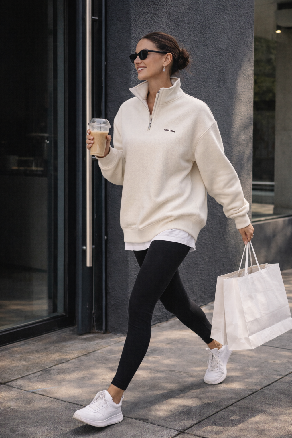 Femme portant un sweat col zippé beige en coton bio KARDAIA, look minimal chic en ville