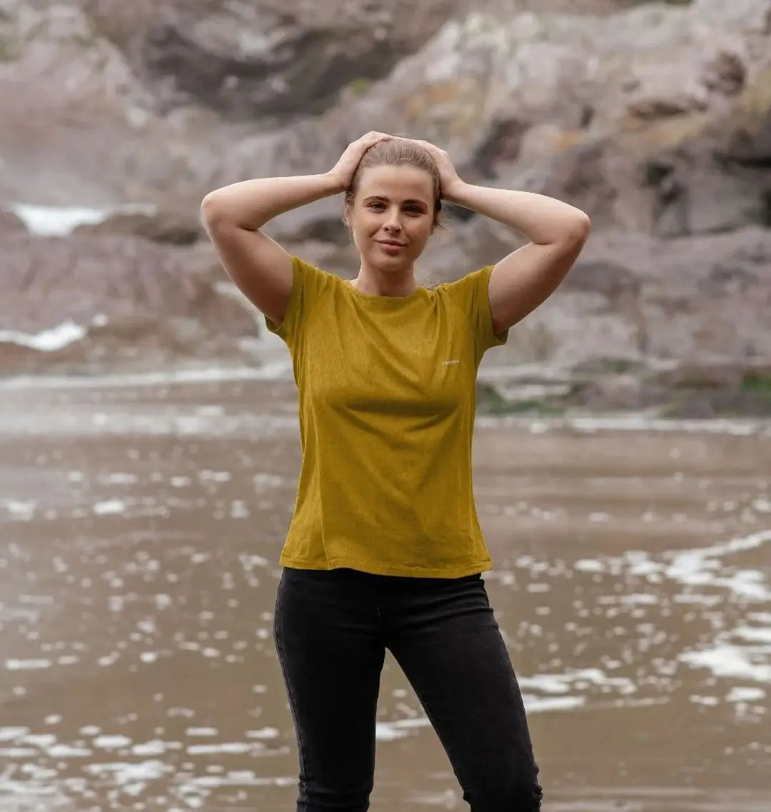 femme portant un t-shirt ocre KARDAIA sur la plage, look naturel et responsable