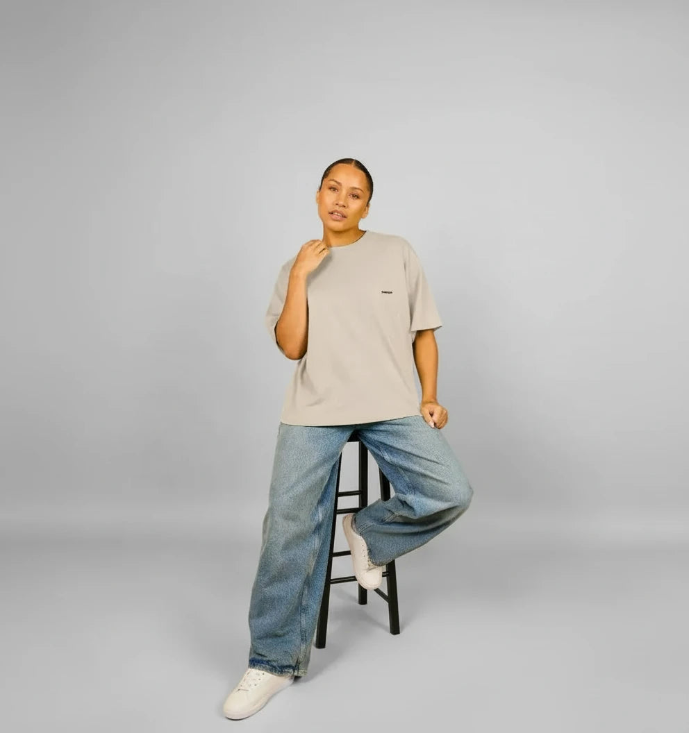 t-shirt oversize beige sable KARDAIA porté par une femme assise sur un tabouret