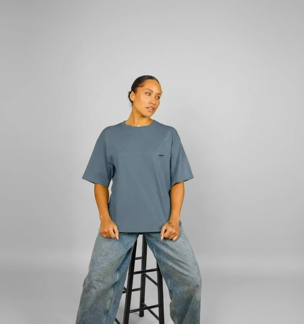 t-shirt oversize bleu ardoise KARDAIA porté par une femme assise sur un tabouret en studio