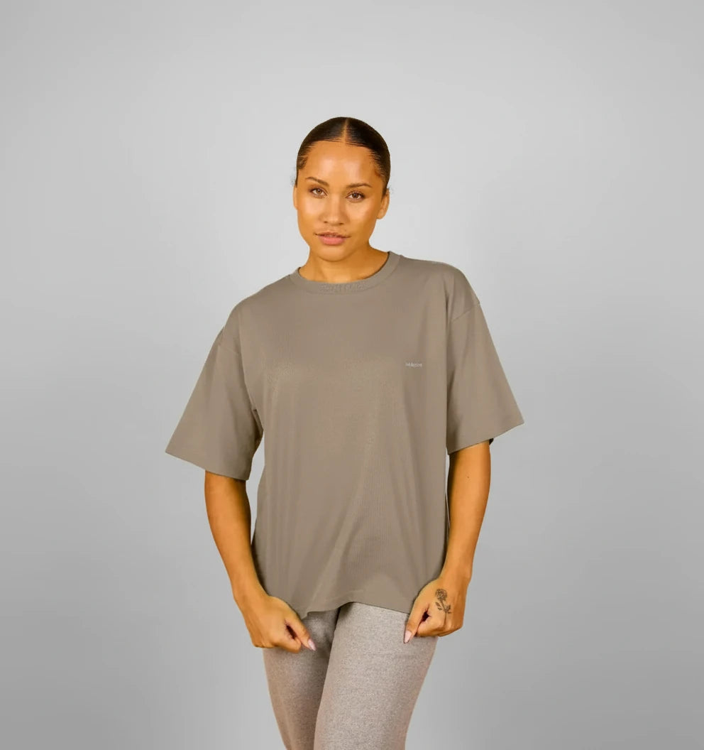 t-shirt oversize kaki terre KARDAIA porté par une femme debout devant fond beige
