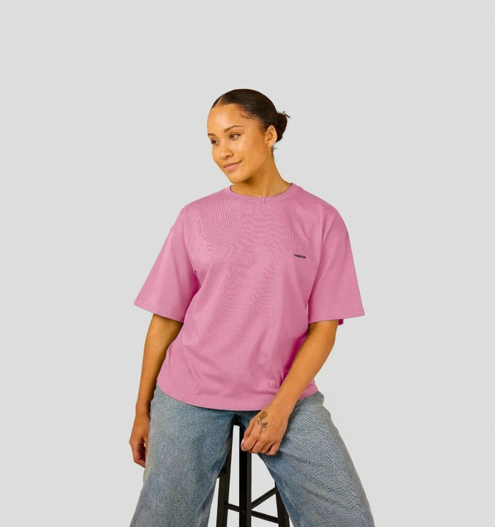 t-shirt oversize rose vif KARDAIA porté par une femme assise sur un tabouret en studio